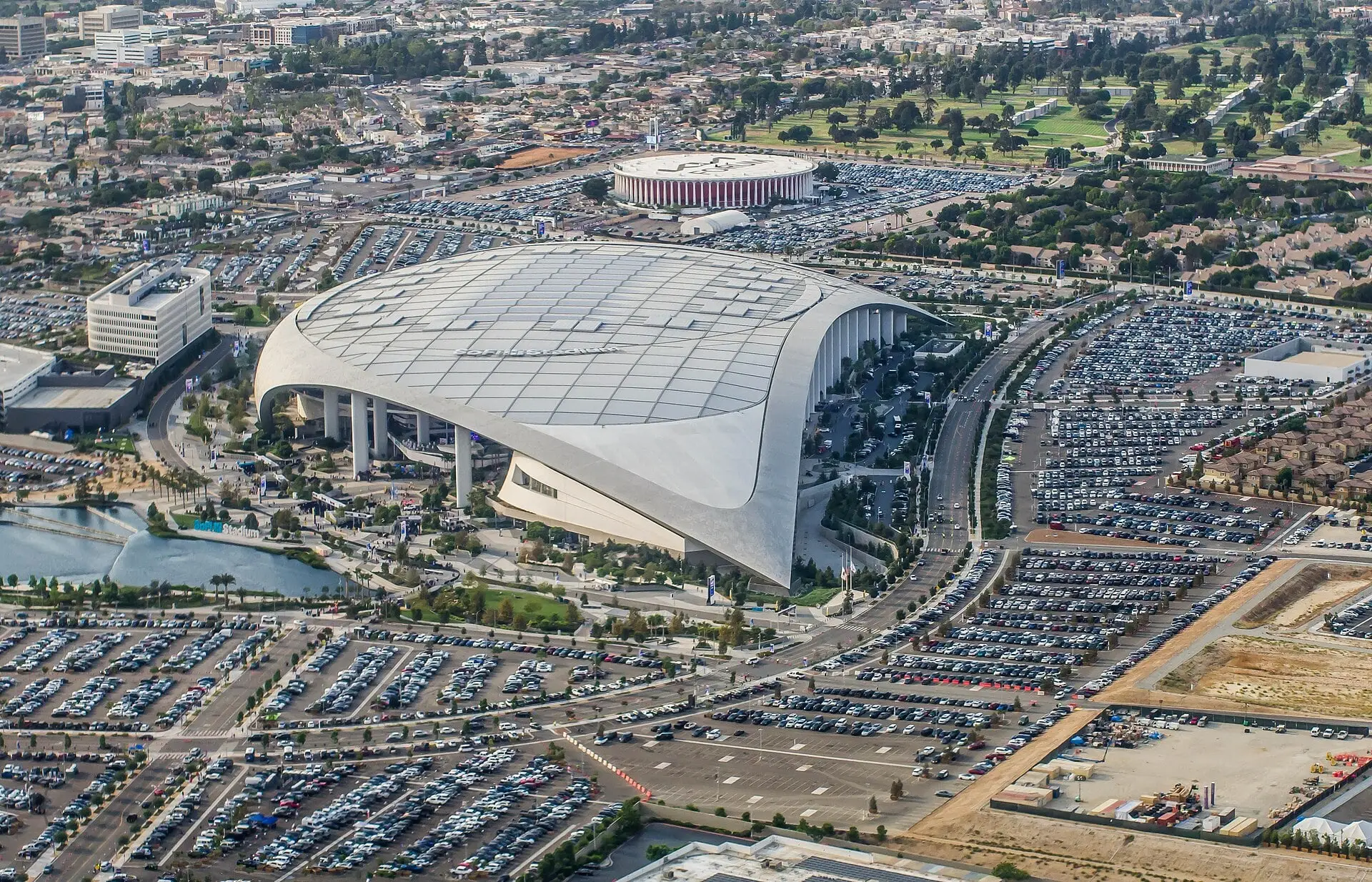 SoFi Stadium on a Rams game day in September 2022 with the Forum visible beyond the parking lot