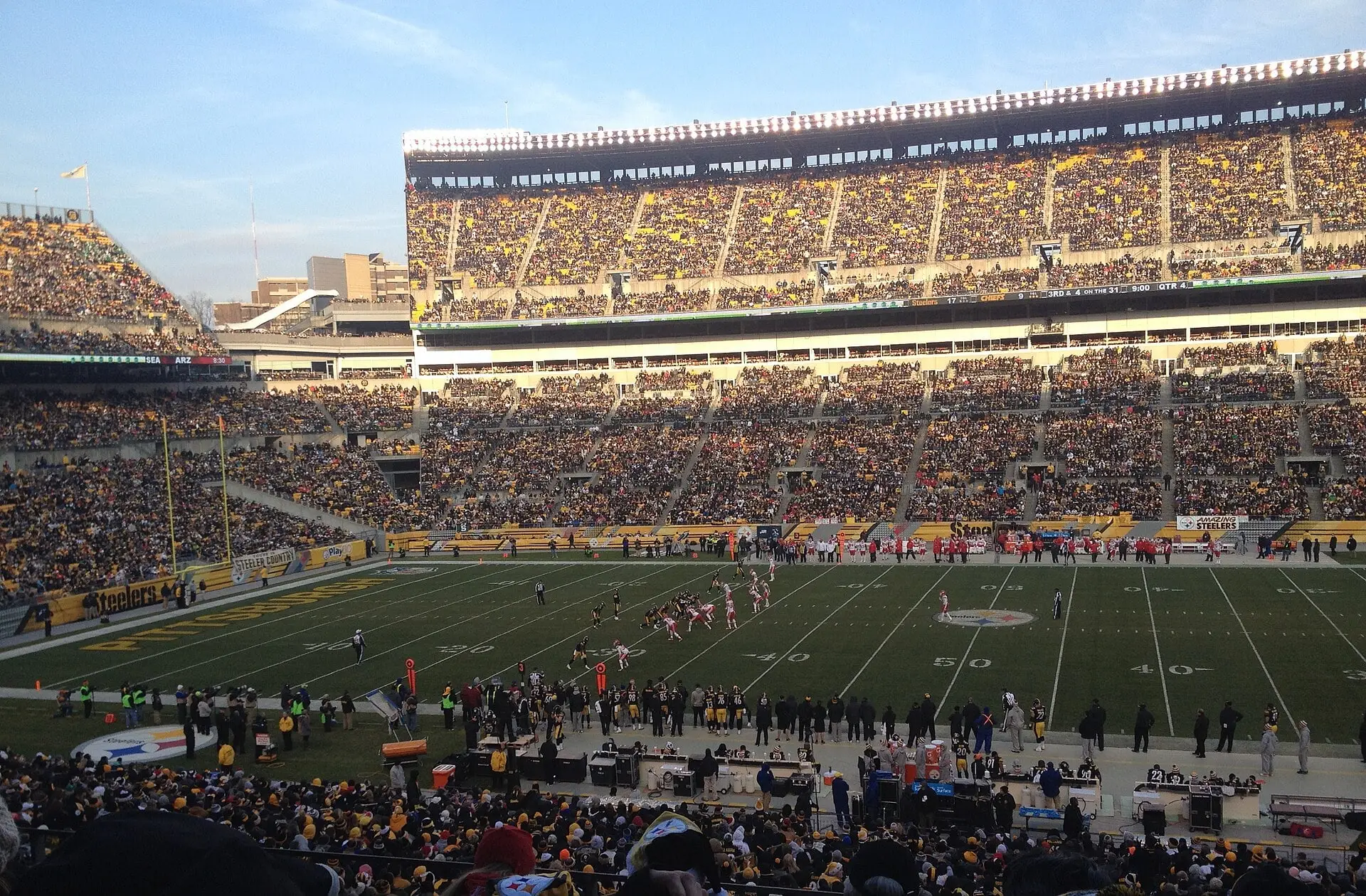 Fans' view across the field at Heinz Field during a December Steelers home game, with the upper deck, scoreboard-side seating and sky behind the end zone