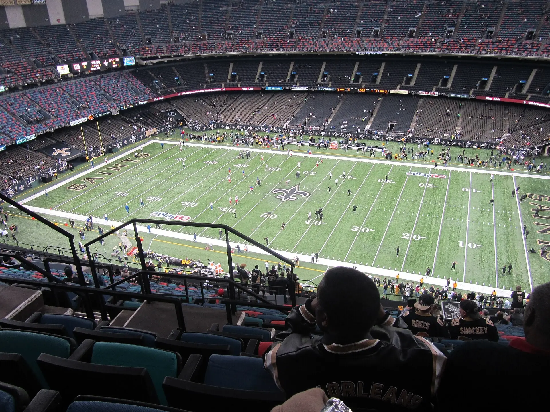 High view from the upper level of the Superdome looking down the length of the field during Saints pregame, with the fleur-de-lis at midfield and both sides of the bowl visible