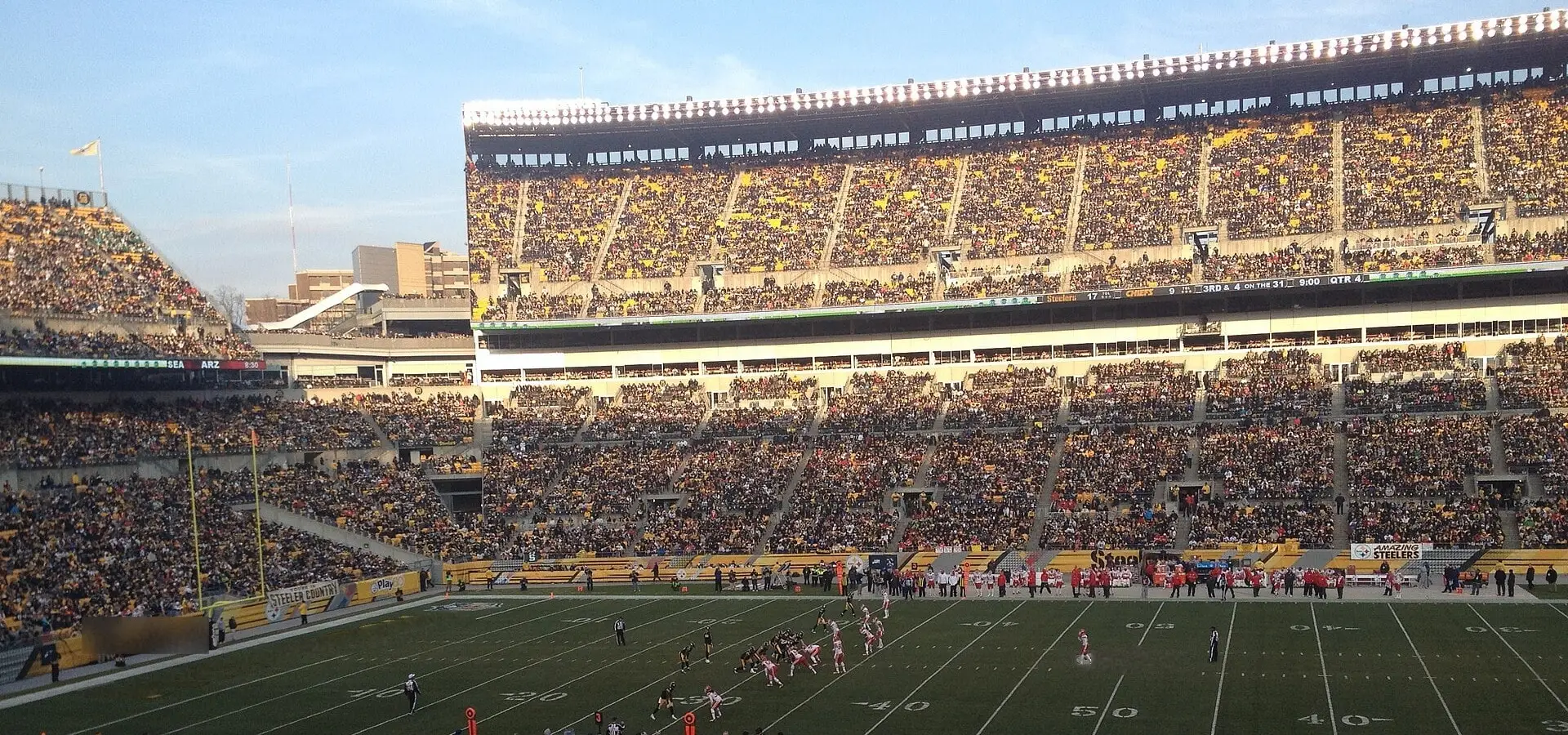 Fans' view across the field at Heinz Field during a December Steelers home game, with the upper deck, scoreboard-side seating and sky behind the end zone